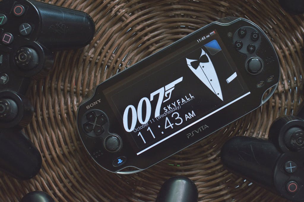 PS Vita showing 007 theme surrounded by PlayStation controllers on a wicker basket.